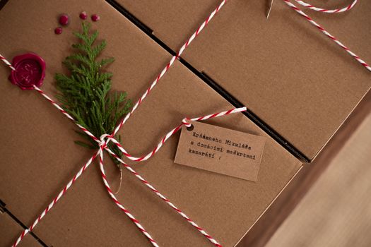 Cadeaux soigneusement emballés dans des boîtes en carton avec une décoration naturelle et une étiquette en kraft.